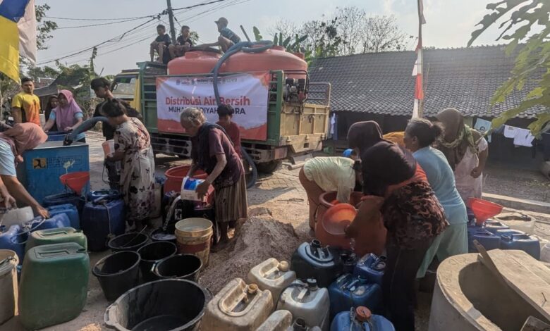 Relawan MDMC Blora mendistribusikan bantuan air bersih ke jeriken dan ember milik warga yang terdampak kekeringan di Blora.