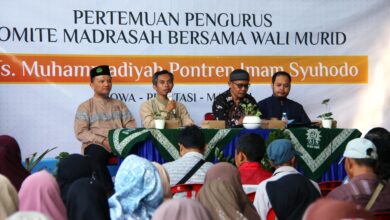 Empat pejabat madrasah duduk di panggung di belakang spanduk untuk rapat wali murid MTs Muhammadiyah Pontren Imam Syuhodo.