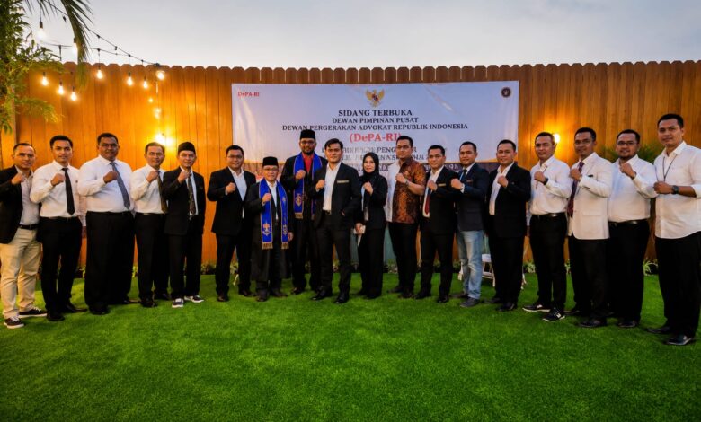 Foto bersama pengurus pusat Dewan Pergerakan Advokat Republik Indonesia (DePA-RI) pada acara Sidang Terbuka Dewan Pimpinan Pusat. Terlihat Ketua Umum DePA-RI TM Luthfi Yazid dan jajaran advokat berpose di depan spanduk acara di sebuah lokasi outdoor di Summer Day Hotel Banjarbaru, dengan latar belakang dinding kayu dan rumput hijau.