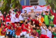 Petugas kepolisian dan para siswa SMP Muhammadiyah 5 Kalinyamatan Jepara melambaikan tangan bersama saat sosialisasi tertib lalu lintas dan pencegahan kenakalan remaja.