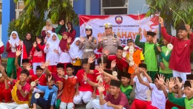 Petugas kepolisian dan para siswa SMP Muhammadiyah 5 Kalinyamatan Jepara melambaikan tangan bersama saat sosialisasi tertib lalu lintas dan pencegahan kenakalan remaja.