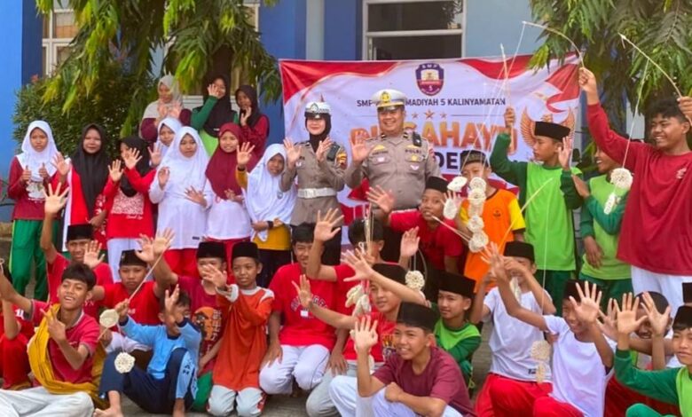 Petugas kepolisian dan para siswa SMP Muhammadiyah 5 Kalinyamatan Jepara melambaikan tangan bersama saat sosialisasi tertib lalu lintas dan pencegahan kenakalan remaja.