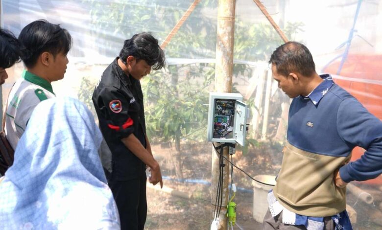 Tim PPK Ormawa HMP PTI UMS dan penilai DKPTI menjelaskan cara kerja alat instalasi IoT Smart Farming UMS kepada warga Desa Seboto Boyolali di dalam greenhouse.