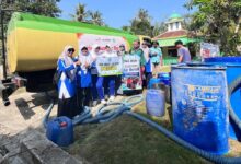 Tim relawan SMA MUH1 Cilacap foto bersama truk tangki saat penyaluran bantuan air bersih Cilacap untuk warga terdampak kekeringan.