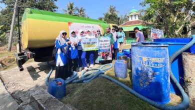 Tim relawan SMA MUH1 Cilacap foto bersama truk tangki saat penyaluran bantuan air bersih Cilacap untuk warga terdampak kekeringan.