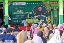 Jamaah menghadiri Pengajian Akbar Hari BerMuhammadiyah Solo Utara dengan latar panggung utama berlatar belakang spanduk hijau.