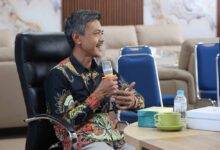 Manajer Eksekutif PWM Jawa Tengah, Ikhwanushoffa, sedang memegang mikrofon dan memaparkan laporan dalam Rapat Pleno Internal PWM Jateng di UNIMUS Semarang.