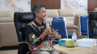 Manajer Eksekutif PWM Jawa Tengah, Ikhwanushoffa, sedang memegang mikrofon dan memaparkan laporan dalam Rapat Pleno Internal PWM Jateng di UNIMUS Semarang.