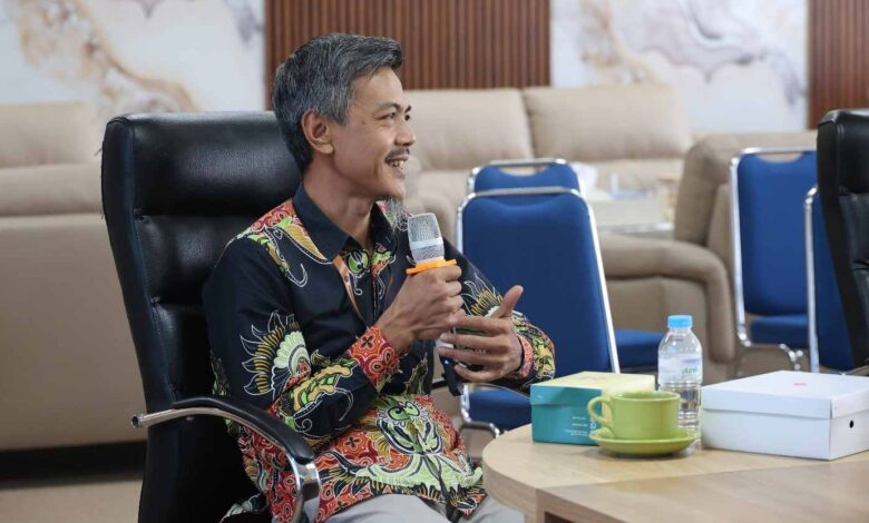 Manajer Eksekutif PWM Jawa Tengah, Ikhwanushoffa, sedang memegang mikrofon dan memaparkan laporan dalam Rapat Pleno Internal PWM Jateng di UNIMUS Semarang.