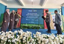 Suasana prosesi pelantikan Kepala Sekolah Muhammadiyah Kota Magelang di atas panggung dengan layar latar bertuliskan Pelantikan dan Serah Terima Jabatan.