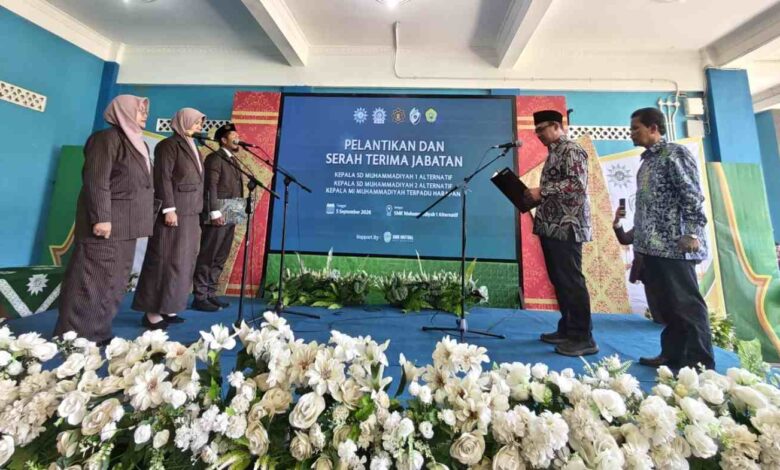 Suasana prosesi pelantikan Kepala Sekolah Muhammadiyah Kota Magelang di atas panggung dengan layar latar bertuliskan Pelantikan dan Serah Terima Jabatan.