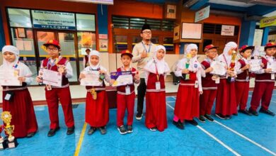 Siswa dan siswi SD Muhammadiyah 1 Ketelan Surakarta berdiri berjejer memegang piala dan sertifikat penghargaan didampingi pembina upacara.