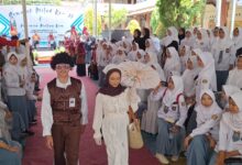 Dua siswa mengenakan gaya busana era 70an melenggak-lenggok di atas catwalk dalam peringatan Milad SMA Muhammadiyah 1 Pekajangan.