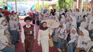 Dua siswa mengenakan gaya busana era 70an melenggak-lenggok di atas catwalk dalam peringatan Milad SMA Muhammadiyah 1 Pekajangan.