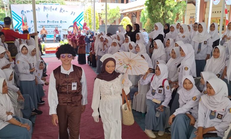 Dua siswa mengenakan gaya busana era 70an melenggak-lenggok di atas catwalk dalam peringatan Milad SMA Muhammadiyah 1 Pekajangan.