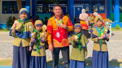 Kepala sekolah bersama guru dan siswa SD Bilingual Muhammadiyah 1 Purwodadi memamerkan medali serta piala kejuaraan Olimpiade Airlangga dan Got Talent di halaman sekolah.