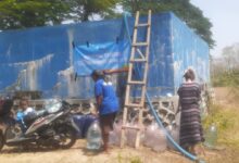 Tim LAZISMU At-Tajdid mendistribusikan bantuan air bersih ke penampungan warga Dusun Pasarsore Blora menggunakan selang dan galon.