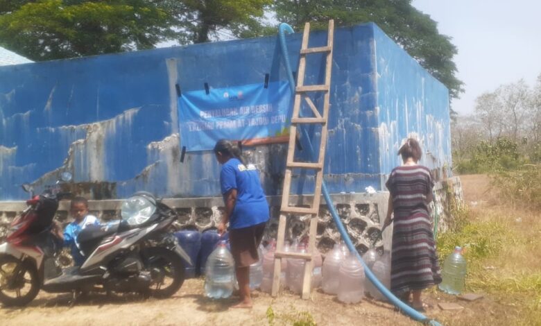 Tim LAZISMU At-Tajdid mendistribusikan bantuan air bersih ke penampungan warga Dusun Pasarsore Blora menggunakan selang dan galon.