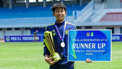 Muhammad Uwais Hardiyanto siswa SMP Mutual Kota Magelang membawa piala dan papan juara runner-up Piala Soeratin U-13 PSSI DIY