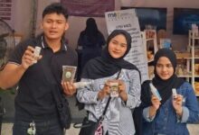 Tiga mahasiswa anggota GenBI memperlihatkan produk inovasi riset dosen UMP di pameran SELARAS 2026.