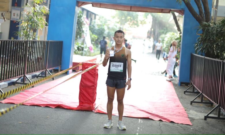 Pelari asal Jawa Barat Muhammad Iman Nudin menunjukkan medali usai menjadi finisher pertama di ajang Edu Fun Run FKIP UMS 2026.