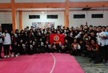 Kontingen Tapak Suci Cilacap foto bersama membentangkan bendera usai raih juara umum Kejurkab Pencak Silat Bupati Cup 2026