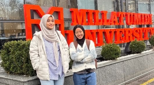 Dua mahasiswa UMS, Weny Anggelina Setya Ningrum dan Vika Yulvani, berfoto di depan tulisan Millat Umidi University Uzbekistan.