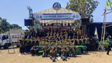 Sekelompok besar kader Hizbul Wathan berfoto bersama di depan panggung utama Jambore Daerah ke-X Kwarda Pemalang dengan barisan piala di depan mereka.