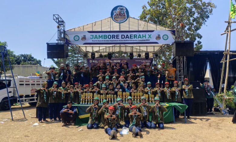 Sekelompok besar kader Hizbul Wathan berfoto bersama di depan panggung utama Jambore Daerah ke-X Kwarda Pemalang dengan barisan piala di depan mereka.