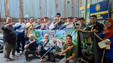 Anggota Komunitas BikersMu Surabaya dan GowesMu Surabaya berfoto bersama membentangkan spanduk aksi bersih-bersih masjid di depan Masjid Da'wah Blauran.