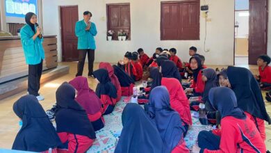 Dua mahasiswa UMS mengenakan almamater hijau memberikan edukasi cegah dampaknya bullying pada anak kepada siswa SDN 01 Wonotoro di Desa Catur Boyolali.