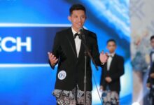 Ghufron Zachri mahasiswa AKMT mengenakan jas hitam dan kain batik sedang berbicara di depan mikrofon saat Grand Final Duta GenRe Temanggung 2026