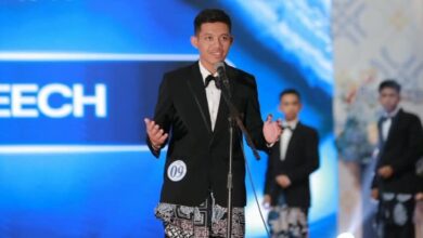 Ghufron Zachri mahasiswa AKMT mengenakan jas hitam dan kain batik sedang berbicara di depan mikrofon saat Grand Final Duta GenRe Temanggung 2026