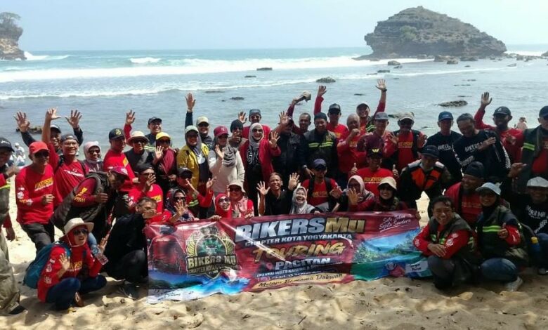 Anggota BikersMu Chapter Kota Yogyakarta berfoto bersama membentangkan spanduk di tepi Pantai Watu Karung Pacitan.