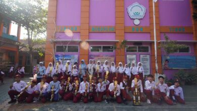Siswa dan siswi SD Muhammadiyah Temanggung memegang piala juara Lomba MAPSI 2026 di depan gedung sekolah.