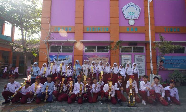 Siswa dan siswi SD Muhammadiyah Temanggung memegang piala juara Lomba MAPSI 2026 di depan gedung sekolah.