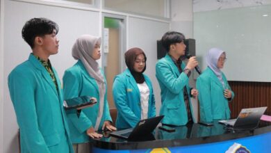 Lima mahasiswa pengembang platform BenerinAja UMS KMI Expo 2026 mengenakan jas almamater hijau tosra sedang melakukan presentasi di depan laptop dan meja ruangan.