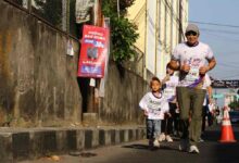 Pelari cilik usia 3 tahun dengan nomor dada A0208 berlari di samping pelari dewasa dalam acara Edu Fun Run FKIP UMS