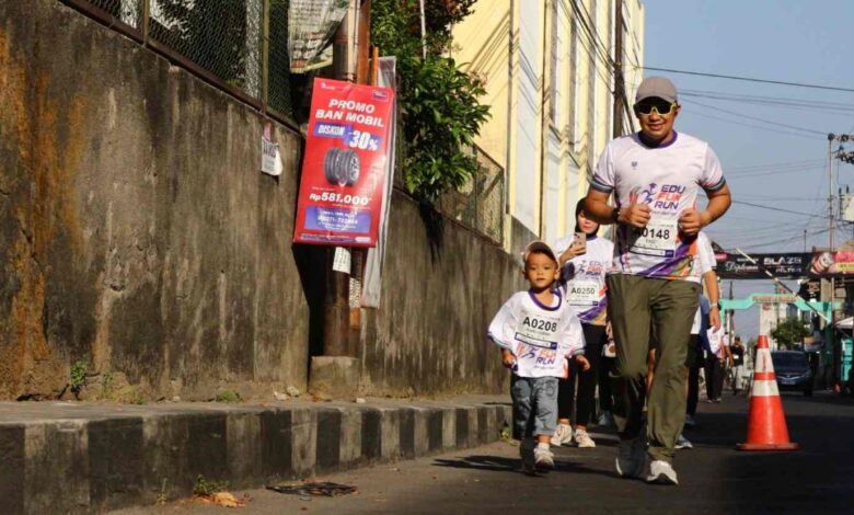 Pelari cilik usia 3 tahun dengan nomor dada A0208 berlari di samping pelari dewasa dalam acara Edu Fun Run FKIP UMS