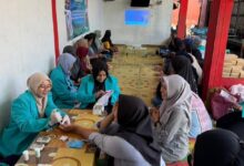 Mahasiswa Fakultas Farmasi UMS sedang melayani pemeriksaan kesehatan dan edukasi penggunaan obat antinyeri untuk lambung kepada warga PKK Sarwo Rukun Surakarta.