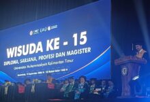 Suasana panggung Sidang Terbuka Senat Wisuda ke-15 UMKT di Samarinda dengan layar latar besar dan pimpinan kampus di mimbar.