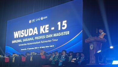 Suasana panggung Sidang Terbuka Senat Wisuda ke-15 UMKT di Samarinda dengan layar latar besar dan pimpinan kampus di mimbar.
