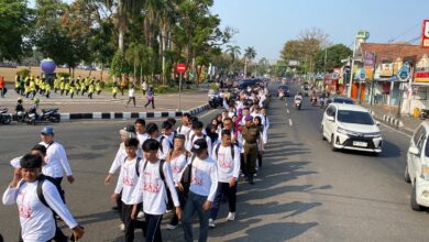 Rombongan mahasiswa baru mengenakan kaos putih berbaris dalam kegiatan Pawai Taaruf UMPWR 2026 di jalanan Kota Purworejo.