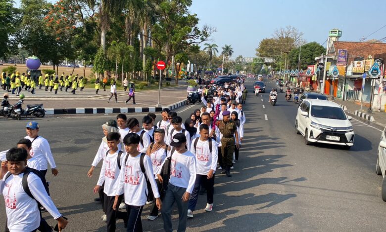 Rombongan mahasiswa baru mengenakan kaos putih berbaris dalam kegiatan Pawai Taaruf UMPWR 2026 di jalanan Kota Purworejo.