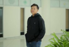 Muhammad Farhan, mahasiswa UMS pemenang Juara 1 lomba review Film Pangku Tempo, berpose mengenakan hoodie hitam di koridor kampus UMS.