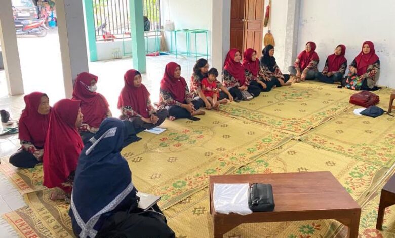 Sekelompok ibu-ibu PKK "Rukun Makmur" Kampung Kaloran, Gayamprit, Klaten, duduk lesehan di atas tikar mengikuti pelatihan manajemen keuangan SIKEPANG v1.0 yang diselenggarakan oleh Tim PkM UMS untuk program ketahanan pangan warga.