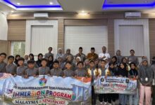 Siswa SD Muhammadiyah Temanggung foto bersama membawa spanduk Immersion Program Goes To Malaysia & Singapore 2026.