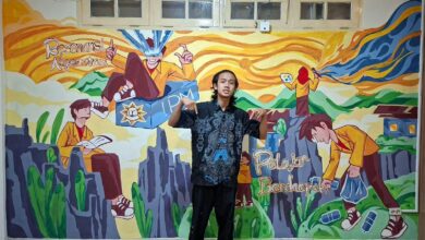 Wildan berdiri di depan mural karya PD IPM Temanggung berjudul Migunani di Era Digital di Kantor PP IPM Yogyakarta.