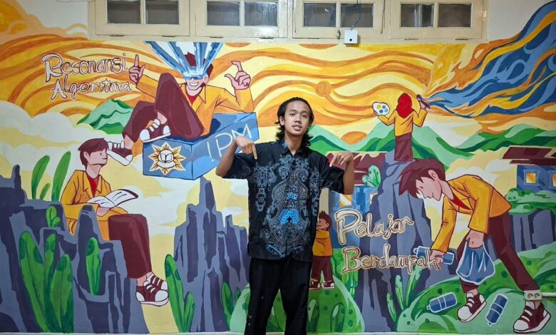 Wildan berdiri di depan mural karya PD IPM Temanggung berjudul Migunani di Era Digital di Kantor PP IPM Yogyakarta.