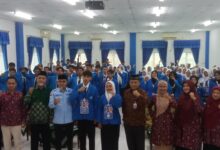 Suasana pembukaan PKKMB STIE Muhammadiyah Cilacap 2026, memperlihatkan para pimpinan kampus, pimpinan PDM, dan peserta mahasiswa baru pose bersama mengepalkan tangan di aula.
